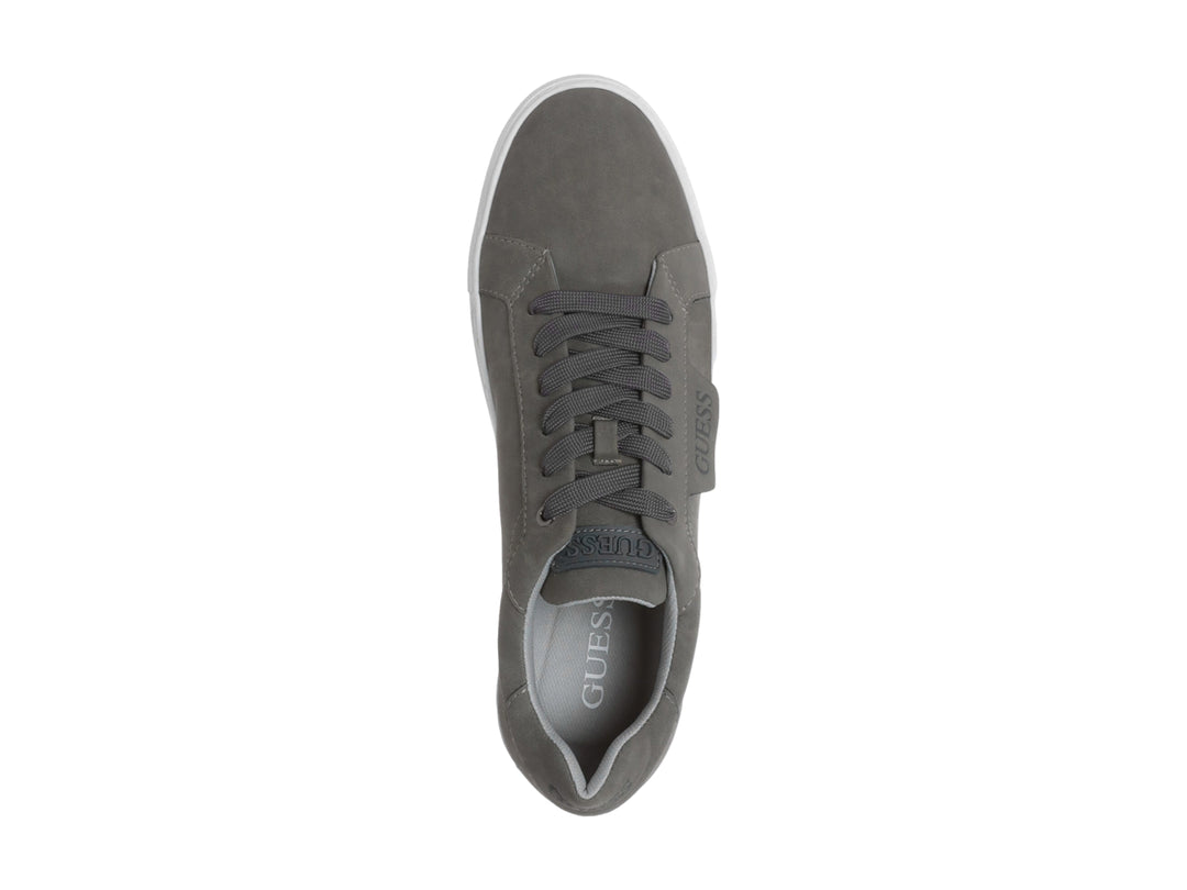 Tenis casuales Guess de color gris con suela blanca y agujetas a juego.