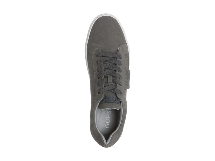 Tenis casuales Guess de color gris con suela blanca y agujetas a juego.