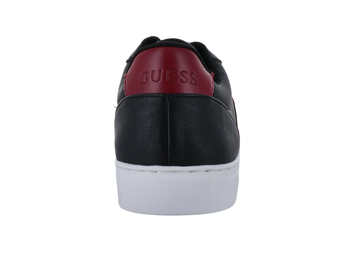 Tenis Guess color negro con suela blanca y detalle rojo en el talón y banda lateral.