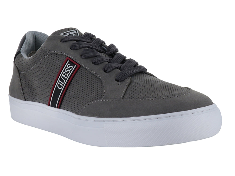 Tenis casuales Guess color gris con suela blanca y detalle de franja lateral.