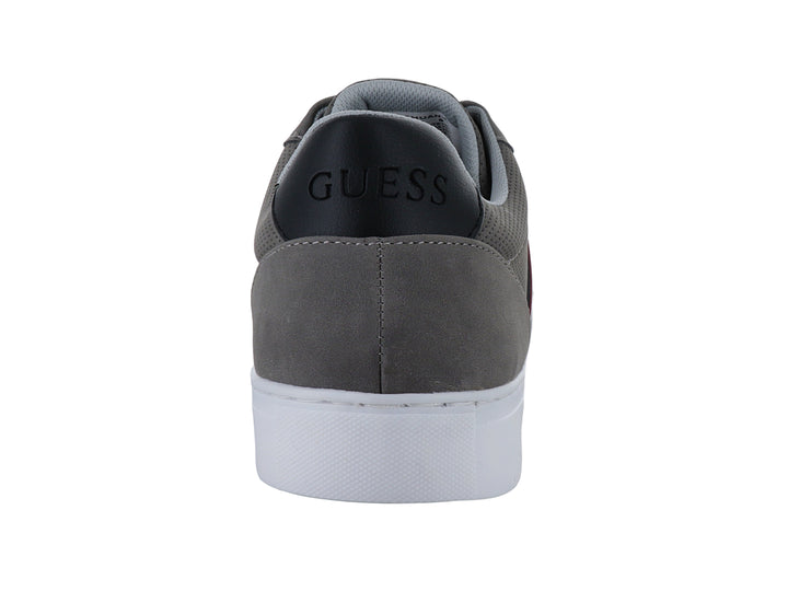 Tenis casuales Guess color gris con suela blanca y detalle de franja lateral.