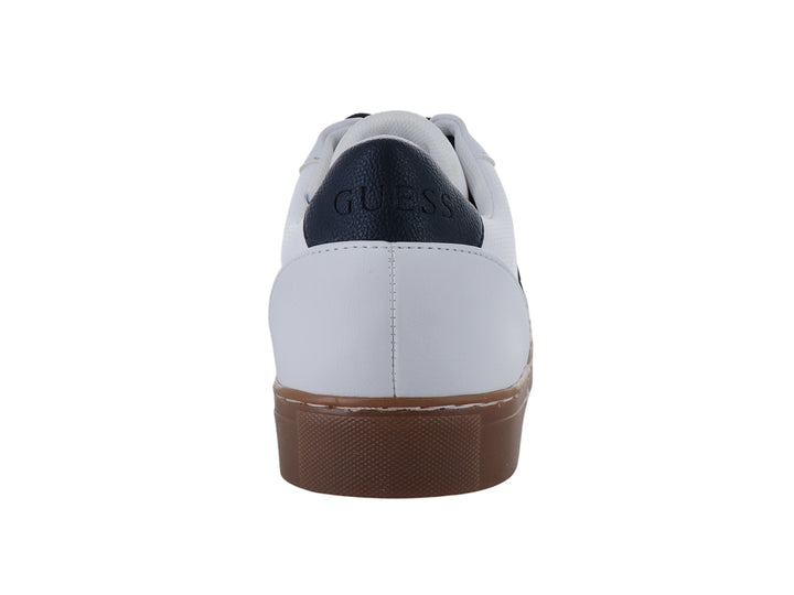 Tenis blancos de la marca Guess con suela color café y detalles en negro.
