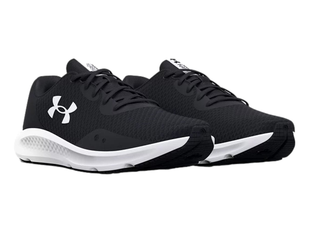 Tenis deportivos Under Armour Charged Pursuit 3 en color negro con suela blanca y logotipo blanco lateral.