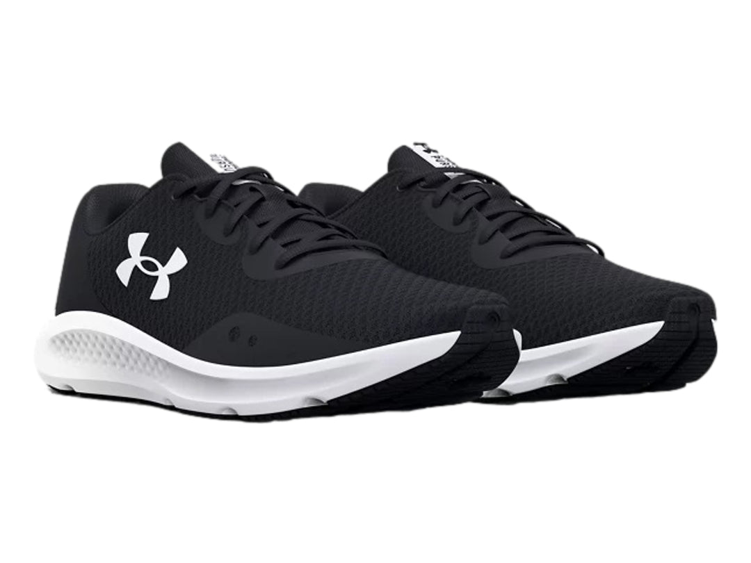 Tenis deportivos Under Armour Charged Pursuit 3 en color negro con suela blanca y logotipo blanco lateral.