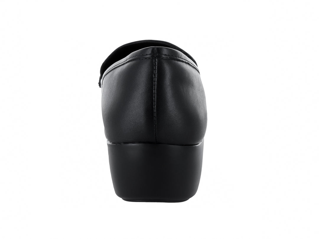 Zapato mocasín de piel negra para mujer con detalle de cadena dorada y suela cómoda.