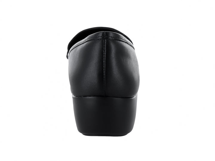 Zapato mocasín de piel negra para mujer con detalle de cadena dorada y suela cómoda.