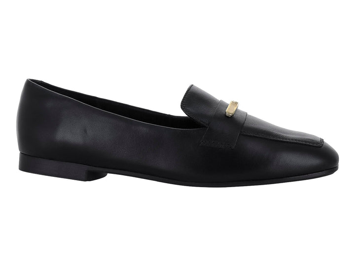 Zapato tipo mocasín de piel color negro con un adorno metálico dorado en la parte superior.