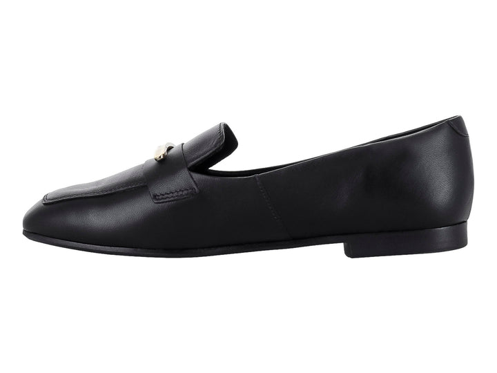Zapato tipo mocasín de piel color negro con un adorno metálico dorado en la parte superior.