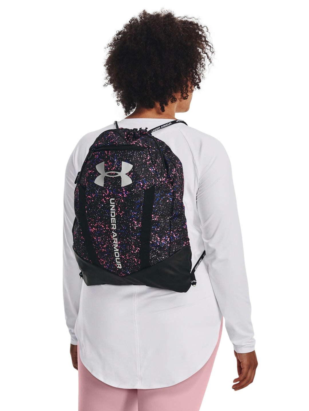 Mochila Under Armour Undeniable Sackpack color negro con estampado multicolor de salpicaduras y logo blanco frontal.