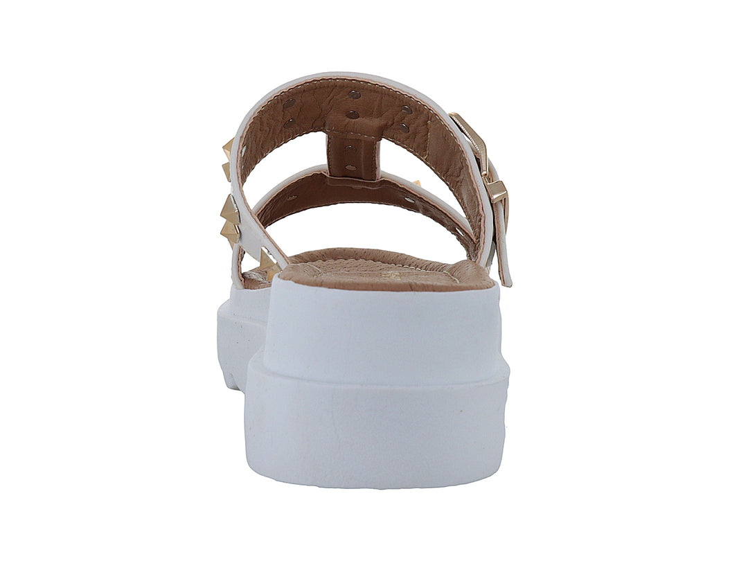 Sandalia color latte con plataforma blanca dentada y detalles de estoperoles dorados.