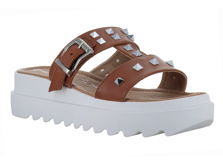 Sandalia color armañac con plataforma blanca, tachuelas metálicas y hebilla.