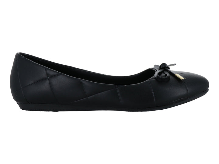 Zapato plano negro con diseño capitonado y moño con detalle dorado.