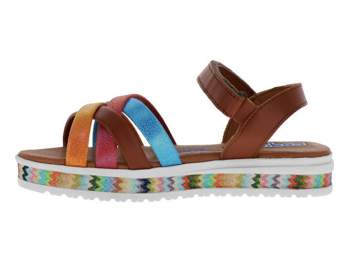 Sandalia color miel con tiras cruzadas en colores rosa, azul y naranja, y suela con diseño zig-zag.