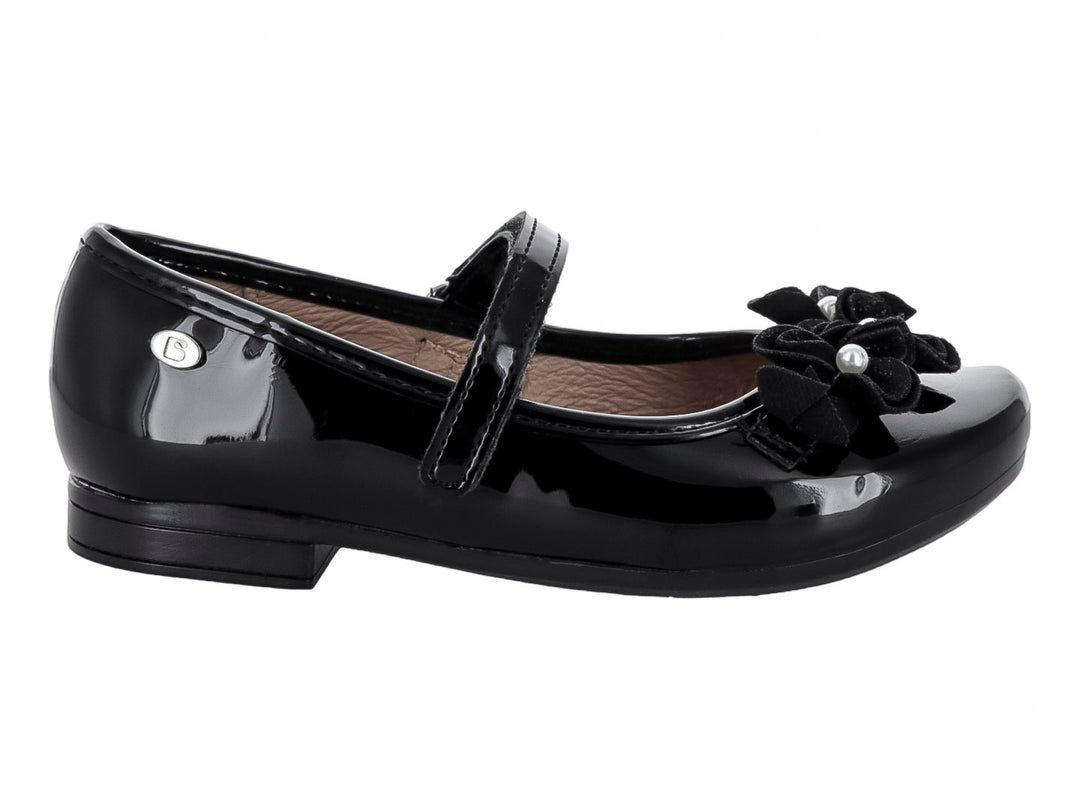 Zapato plano negro de charol para niña con correa y adorno de moño con perlas en la punta.