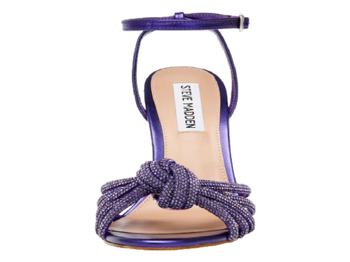 Sandalia de tacón alto color morado con detalle de nudo frontal y correa al tobillo.