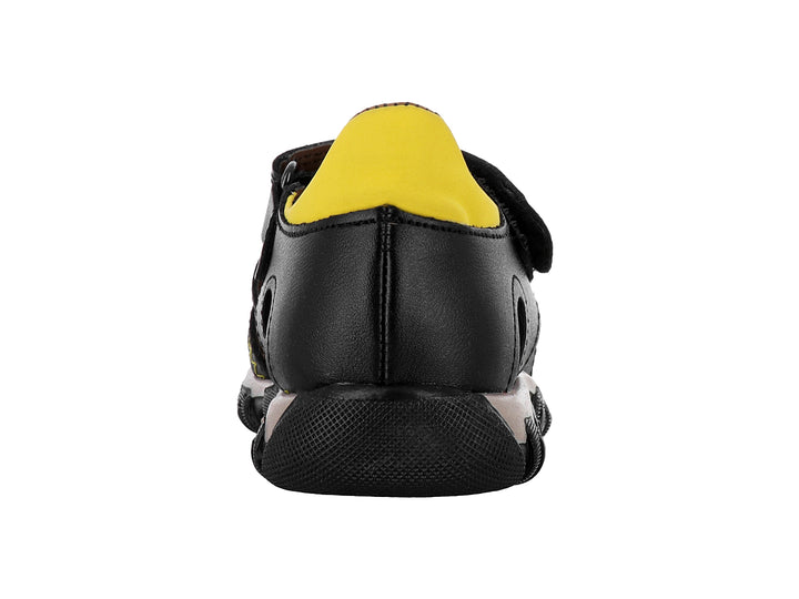 Sandalia negra para niño con detalles en amarillo y suela beige robusta.