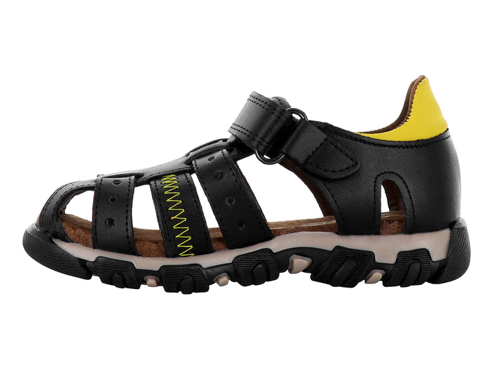 Sandalia cerrada negra para niño con detalles en amarillo y suela robusta color café.