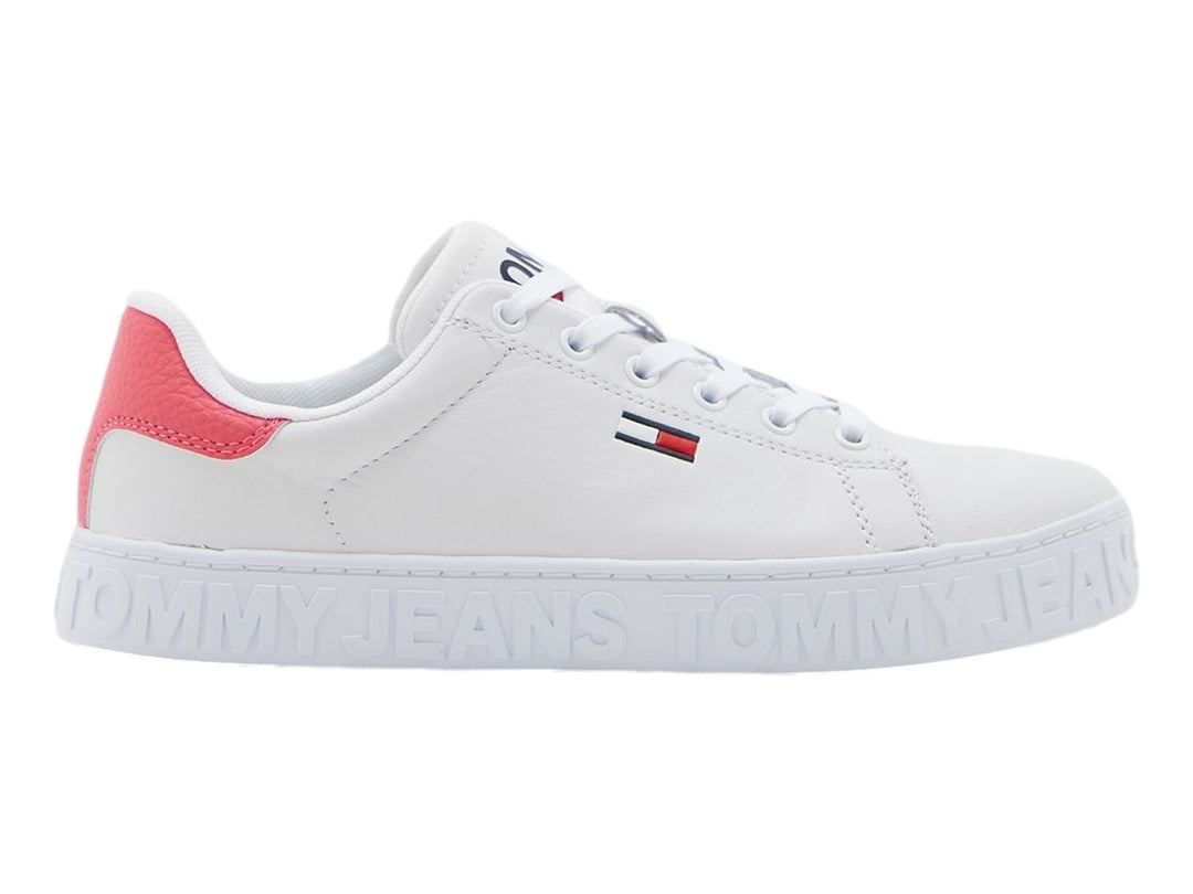 Tenis blancos Tommy Hilfiger con detalle rosa en el talón y suela con texto Tommy Jeans en relieve.