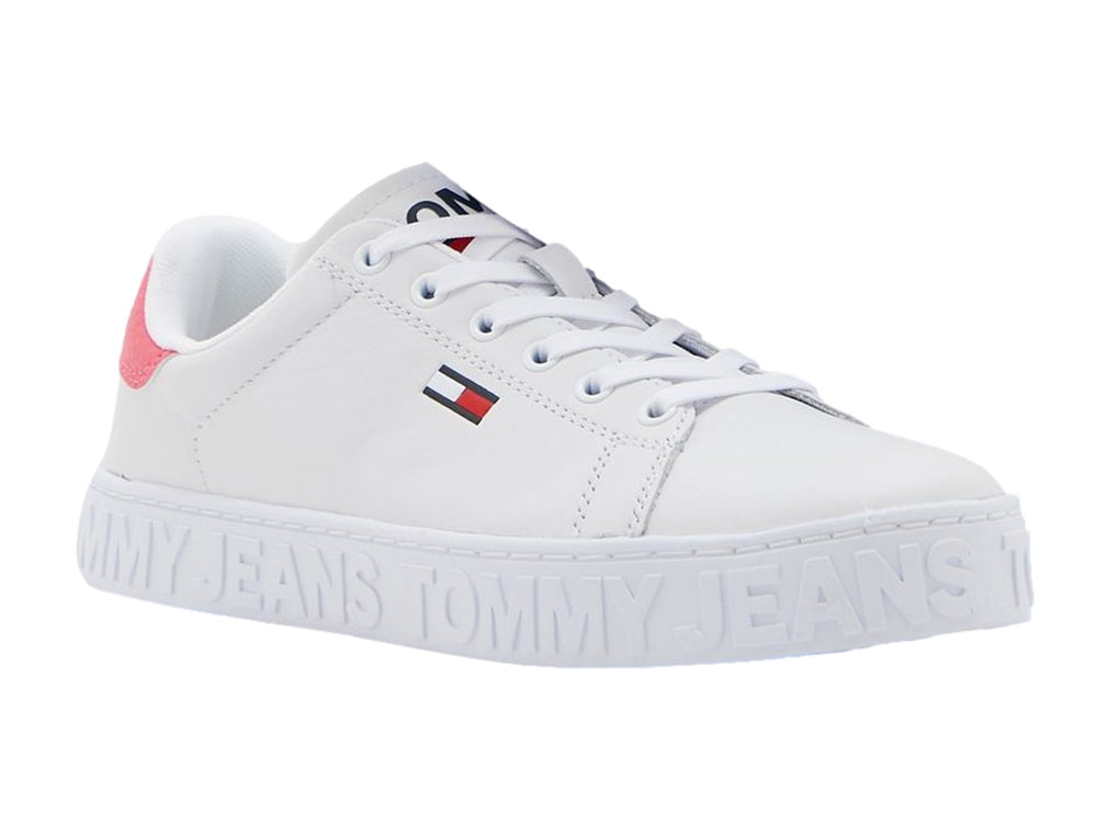 Tenis blancos Tommy Hilfiger con detalle rosa en el talón y suela con texto Tommy Jeans en relieve.