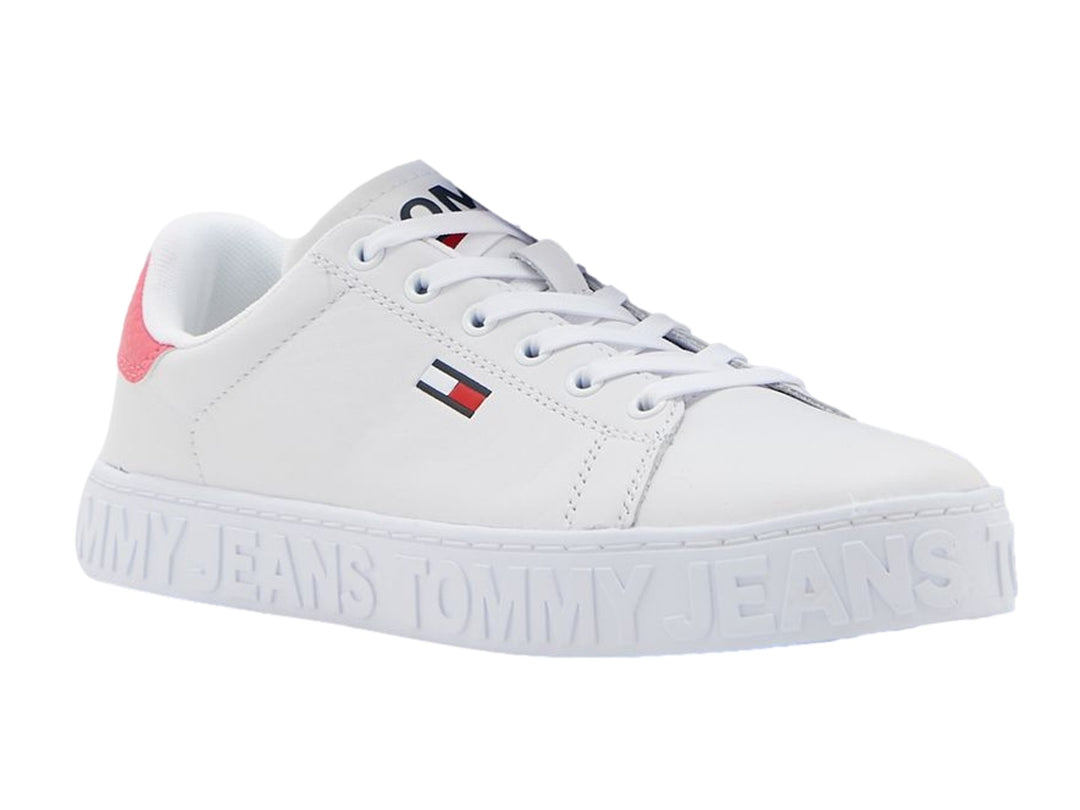 Tenis blancos Tommy Hilfiger con detalle rosa en el talón y suela con texto Tommy Jeans en relieve.