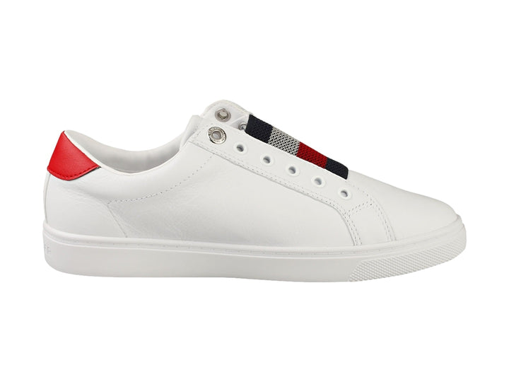 Tenis Tommy Hilfiger blancos estilo slip-on con banda elástica tricolor y detalle rojo en el talón.