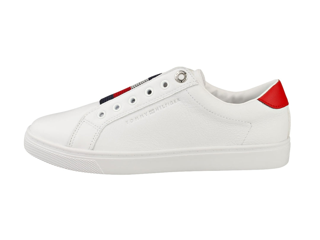 Tenis Tommy Hilfiger blancos estilo slip-on con banda elástica tricolor y detalle rojo en el talón.