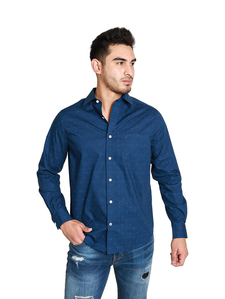 Hombre vistiendo una camisa azul marino de manga larga con pequeños puntos blancos.