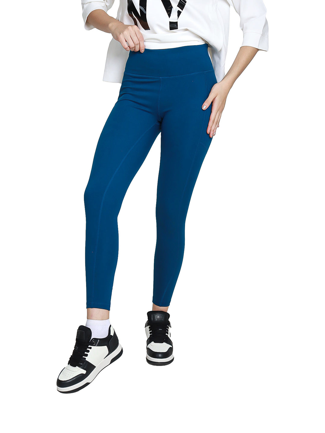 Mujer vistiendo leggings deportivos DKNY color azul Poseidon de cintura alta y largo 7/8.