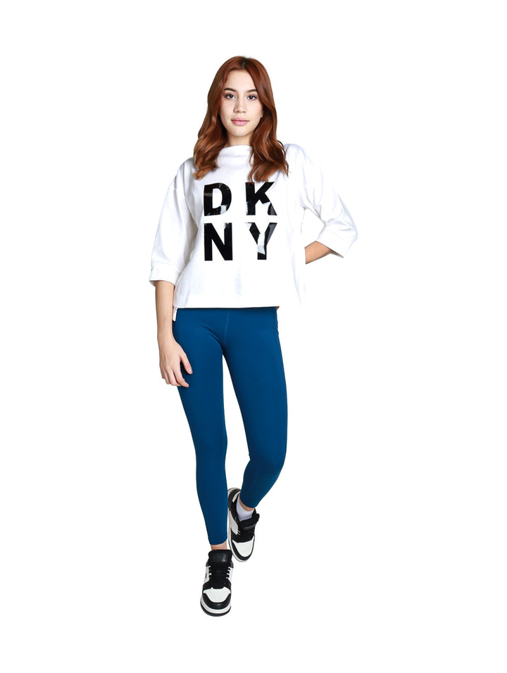 Mujer vistiendo leggings deportivos DKNY color azul Poseidon de cintura alta y largo 7/8.