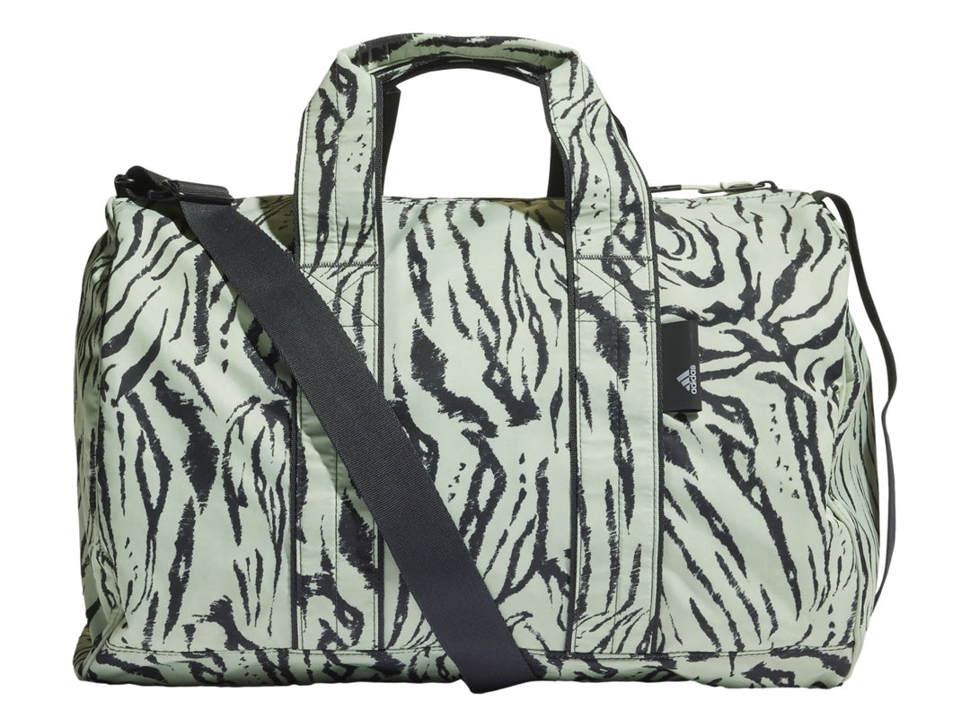 Bolso deportivo Adidas modelo Duffel en color verde lino con estampado animal tipo cebra y correa negra.