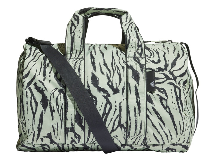 Bolso deportivo Adidas modelo Duffel en color verde lino con estampado animal tipo cebra y correa negra.