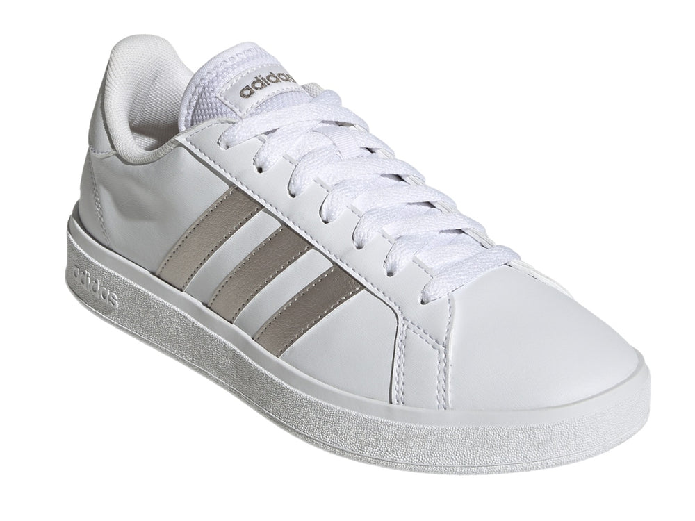 Tenis Adidas blancos con franjas laterales en color plata metálico y suela blanca.