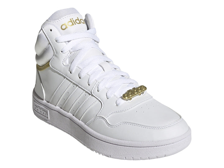 Tenis Adidas Hoops 3.0 Mid en color blanco con detalles metálicos dorados y suela blanca.