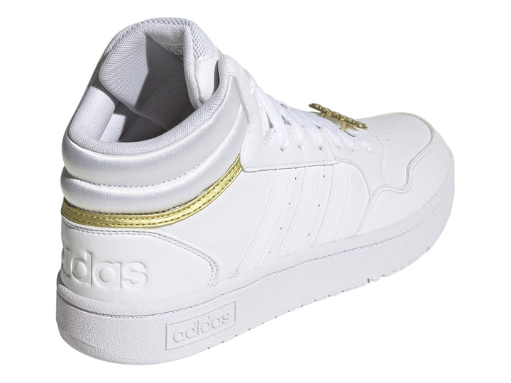 Tenis Adidas Hoops 3.0 Mid en color blanco con detalles metálicos dorados y suela blanca.