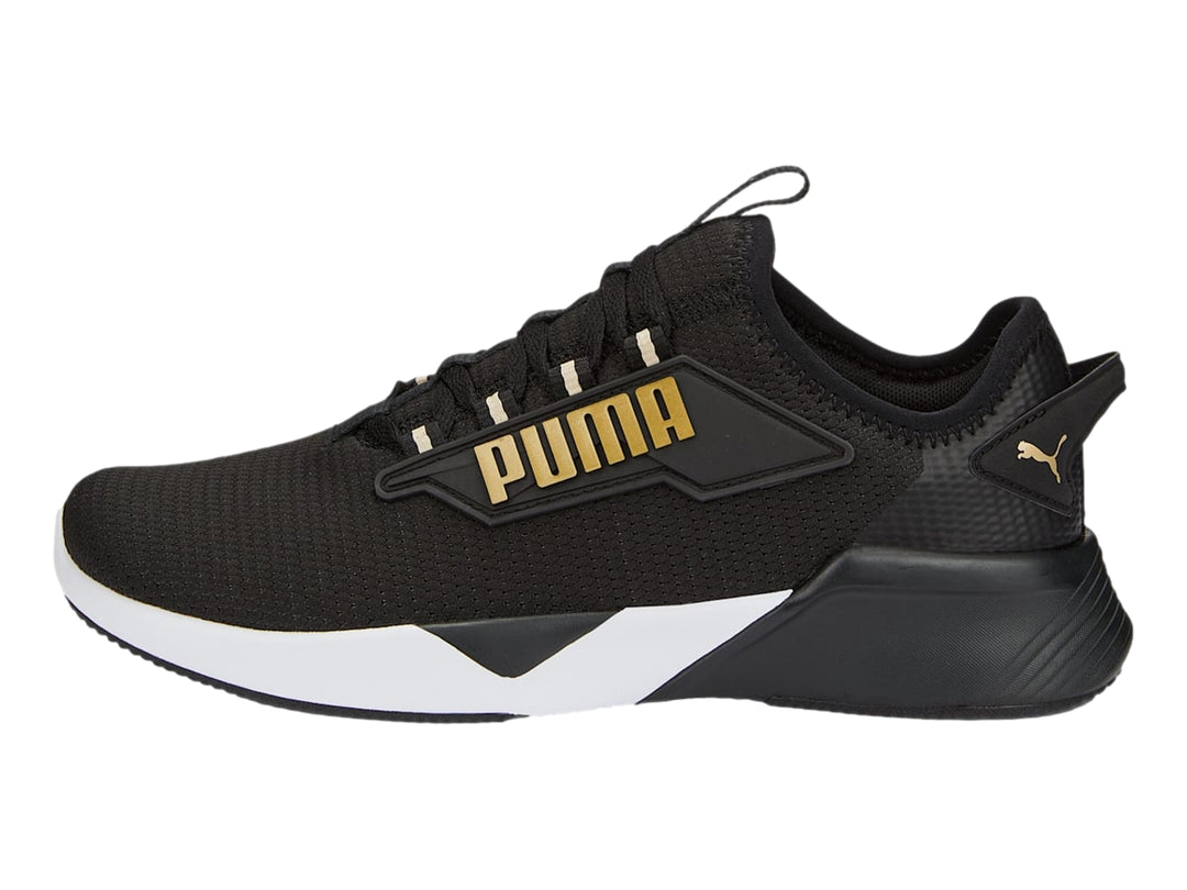 Tenis deportivos PUMA Retaliate 2 color negro con suela blanca y detalles dorados.