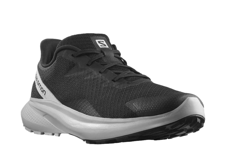 Tenis deportivos Salomon en color negro con suela gris claro y detalles laterales en blanco.