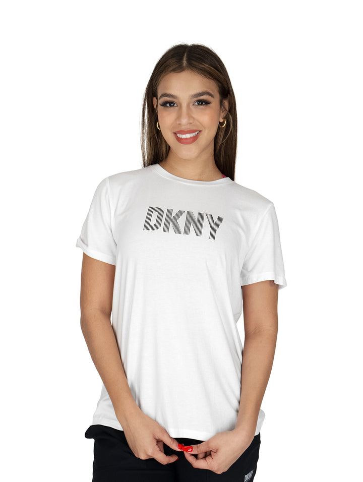 Mujer vistiendo una playera blanca de manga corta con el logotipo DKNY en el pecho.