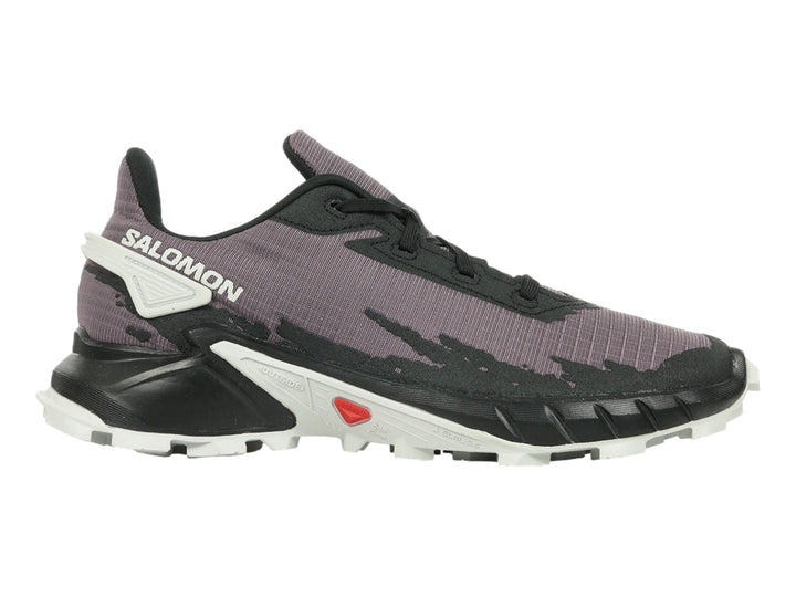 Tenis deportivos Salomon color morado y negro con suela blanca y detalles rojos.
