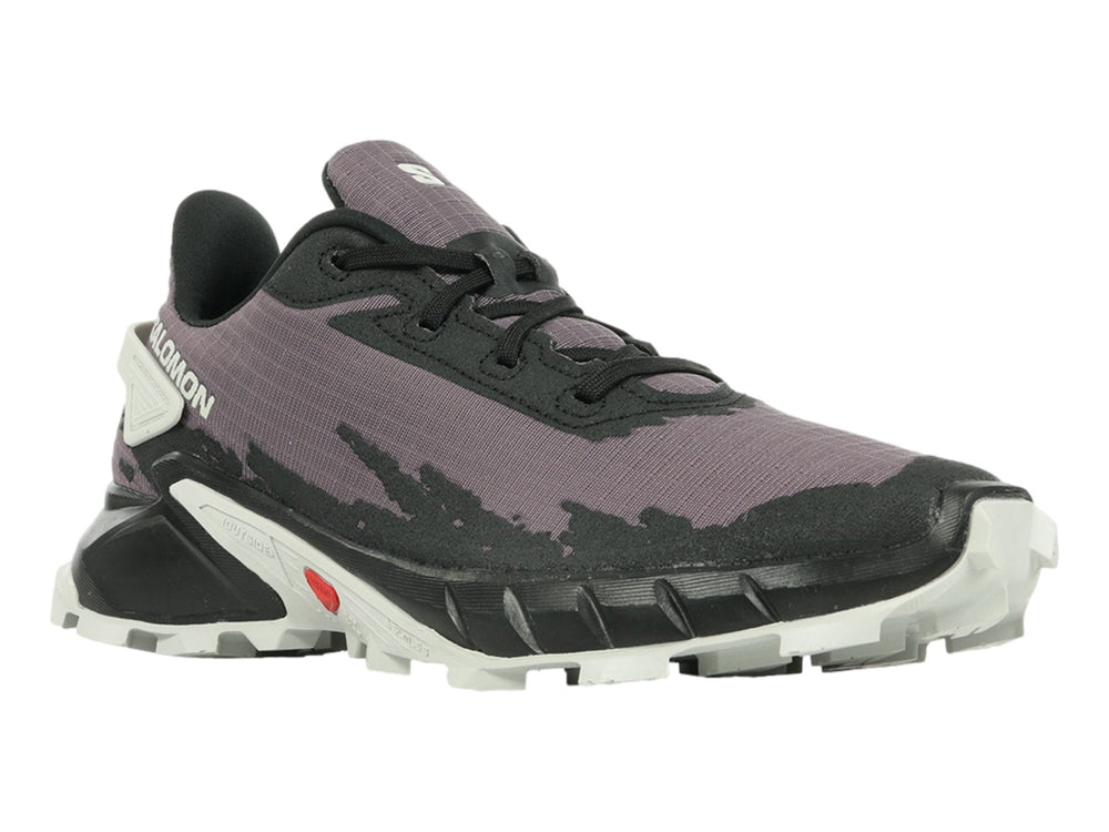 Tenis deportivos Salomon color morado y negro con suela blanca y detalles rojos.
