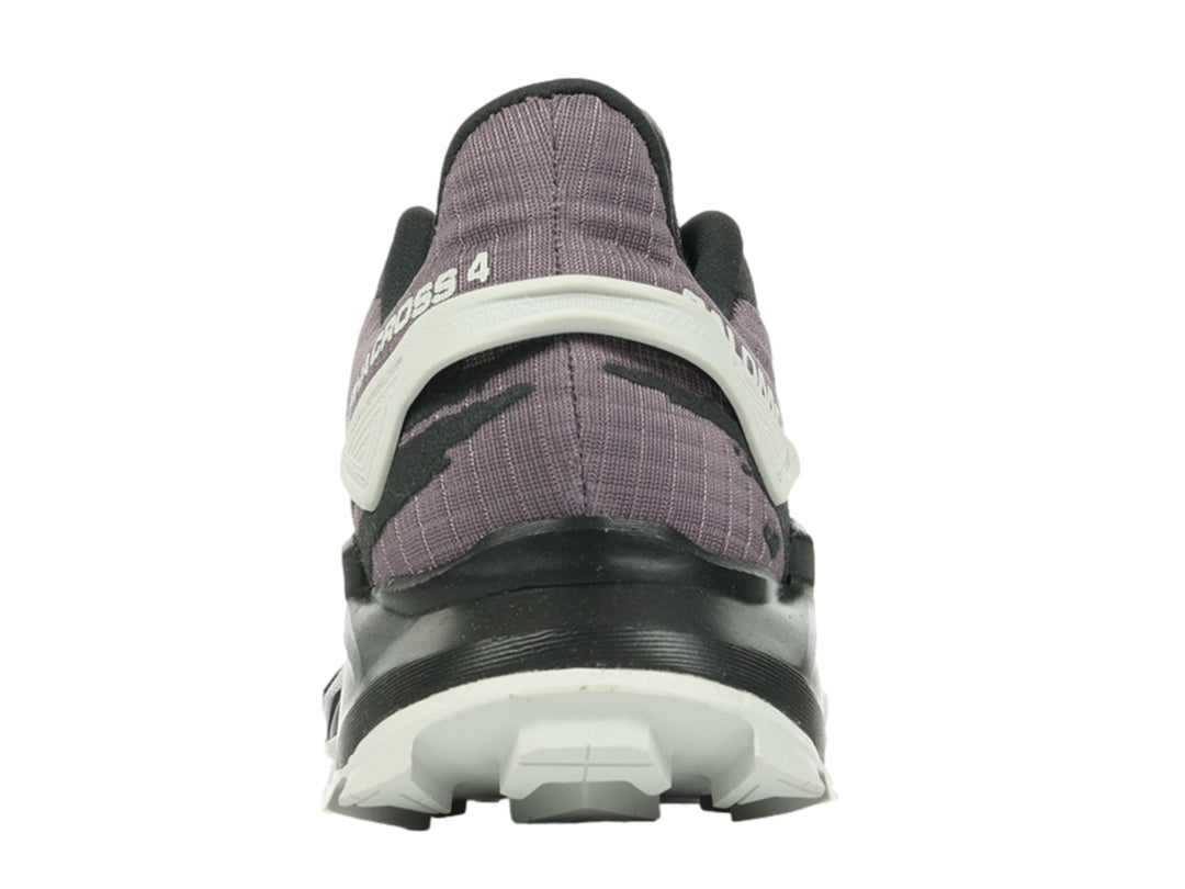 Tenis deportivos Salomon color morado y negro con suela blanca y detalles rojos.