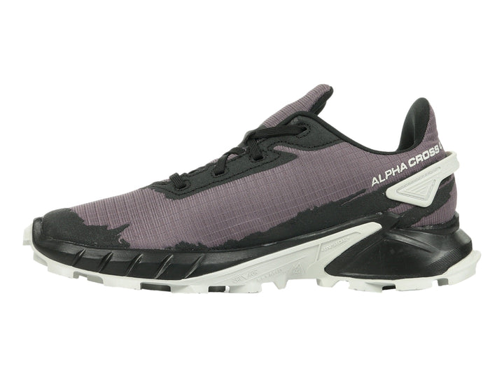 Tenis deportivos Salomon color morado y negro con suela blanca y detalles rojos.