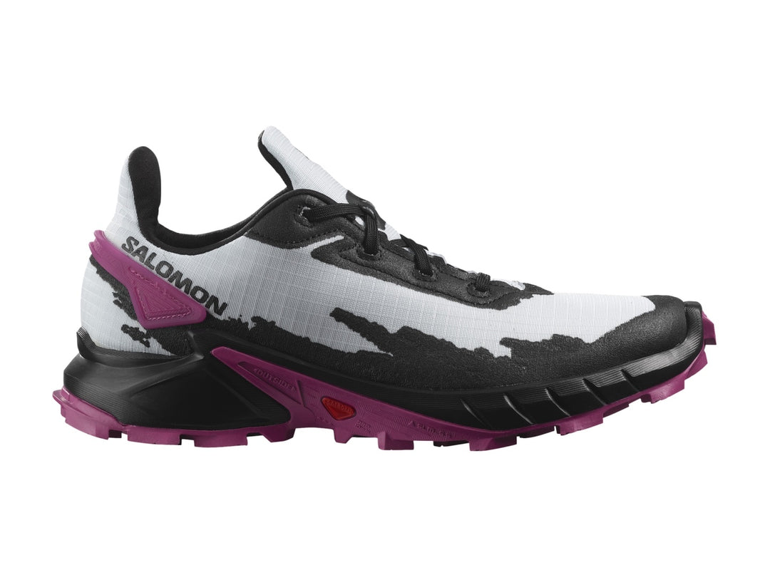 Tenis deportivos Salomon Alphacross en colores blanco, negro y morado con suela rugosa para trail.