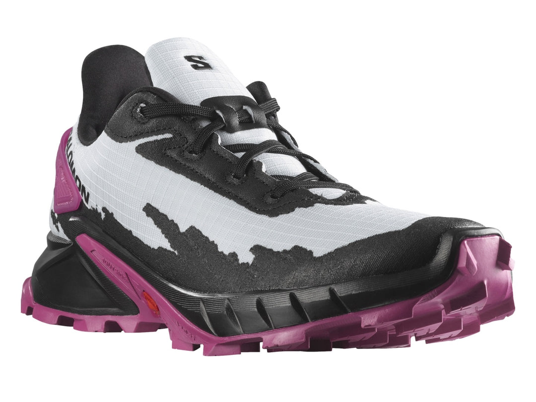 Tenis deportivos Salomon Alphacross en colores blanco, negro y morado con suela rugosa para trail.
