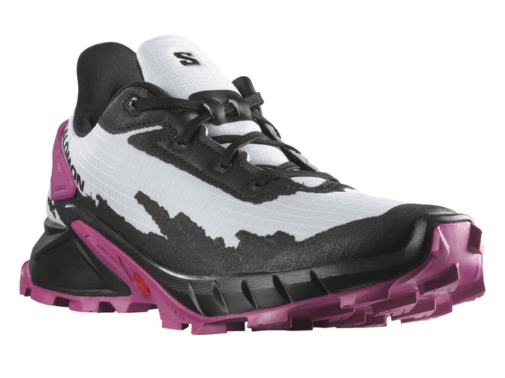 Tenis deportivos Salomon Alphacross en colores blanco, negro y morado con suela rugosa para trail.