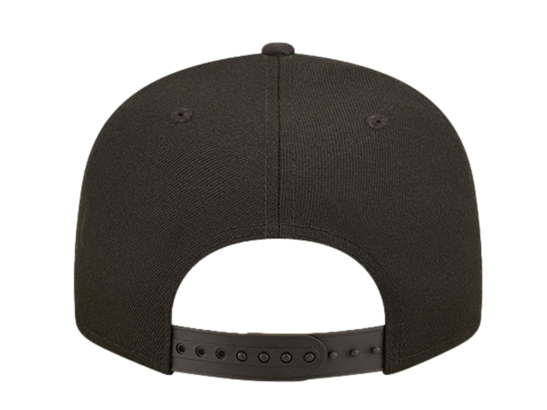 Gorra New Era negra con logo bordado en dorado y visera con estampado de camuflaje oscuro.