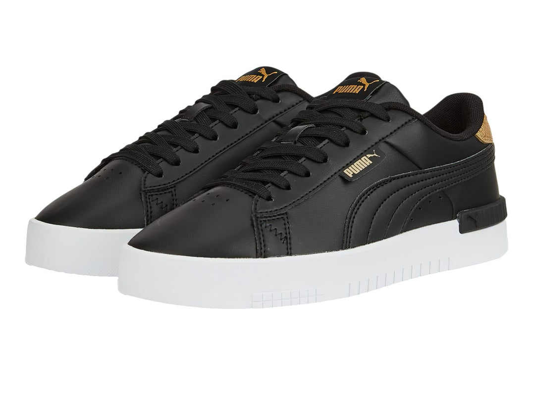 Tenis PUMA color negro con detalles en dorado y suela blanca.