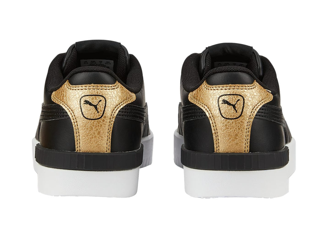 Tenis PUMA color negro con detalles en dorado y suela blanca.