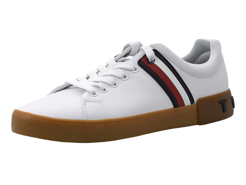 Tenis Tommy Hilfiger color blanco con suela marrón y franjas decorativas en azul y rojo en el lateral.