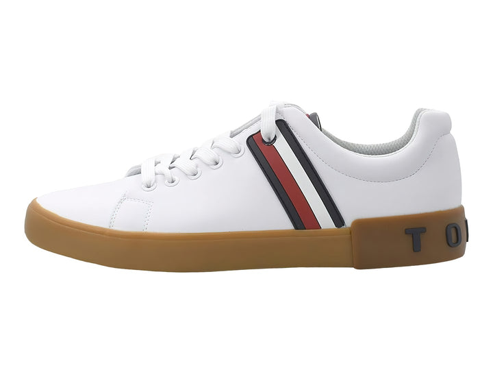 Tenis Tommy Hilfiger color blanco con suela marrón y franjas decorativas en azul y rojo en el lateral.