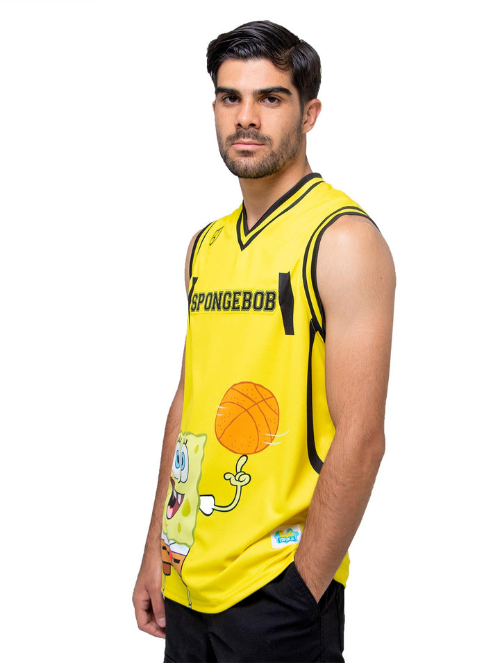 Jersey de basquetbol amarillo con estampado de Bob Esponja y detalles en negro, usado por un hombre.